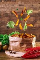volante fette di al forno Patata su di legno sfondo. lattuga, paprica, prezzemolo. Fast food. foto