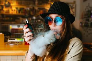 vaping ragazza. giovane fricchettone donna Vape e-cig a il vapeshop. hip-hop stile. avvicinamento. foto