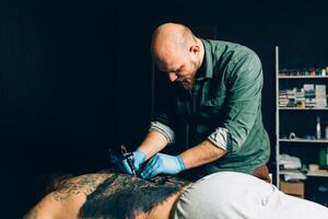 tatuaggio maestro artista fa un' tatuaggio. avvicinamento foto