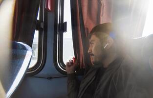 sorridente giovane uomo in viaggio e seduta nel economico autobus, con spazio per testo foto