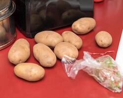 alcuni ruggine patate in attesa per essere pelato e poi schiacciato per un' famiglia cena foto