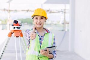 asiatico donna ingegnere lavoratore opera nel costruzione luogo. inteligente costruttore architetto femmina nel sicurezza suite Lavorando. foto