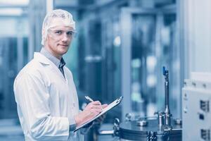 ritratto medicina fabbrica scienziato lavoratore opera nel laboratorio impianti processi. medico medico Lavorando ricerca nel farmaceutico industria guardare Sorridi. foto