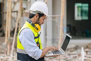 costruzione ingegnere caposquadra Lavorando contatto con il computer portatile computer nel costruzione luogo foto