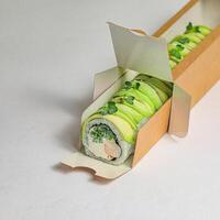 Sushi scatola con verde verdura otturazioni e rotolo foto