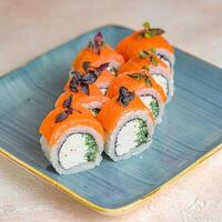 blu piatto con Sushi coperto nel salsa foto