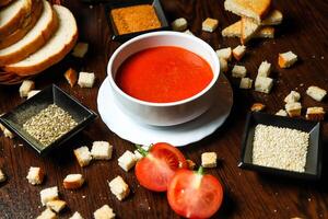 ciotola di pomodoro la minestra con fette di pane foto