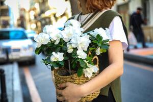 donna Tenere cestino di bianca fiori foto