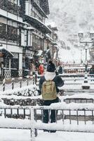 donna turista visitare ginzan onsen nel yamagata, contento viaggiatore giro turistico giapponese onsen villaggio con neve nel inverno stagione. punto di riferimento e popolare per attrazione nel Giappone. viaggio e vacanza concetto foto