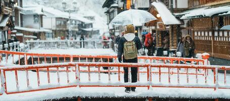 donna turista visitare ginzan onsen nel yamagata, contento viaggiatore giro turistico giapponese onsen villaggio con neve nel inverno stagione. punto di riferimento e popolare per attrazione nel Giappone. viaggio e vacanza concetto foto