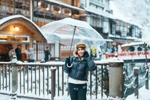 donna turista visitare ginzan onsen nel yamagata, contento viaggiatore giro turistico giapponese onsen villaggio con neve nel inverno stagione. punto di riferimento e popolare per attrazione nel Giappone. viaggio e vacanza concetto foto