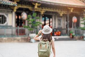 donna viaggiatore visitare nel taiwan, turista con cappello giro turistico nel longshan tempio, Cinese popolare religioso tempio nel wanhua quartiere, taipei città. punto di riferimento e popolare. viaggio e vacanza concetto foto