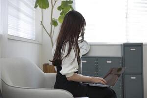 un' Lavorando giapponese donna di a distanza opera nel il casa ufficio avvicinamento foto