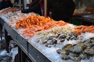 ai generato fresco frutti di mare su ghiaccio a mercato Schermo. foto