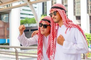 giovane arabo uomo d'affari celebrare vittoria sensazione a partire dal successo, musulmano uomo colleghi celebrare condivisa attività commerciale successo o vittoria foto