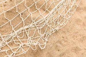 a rete su il sabbia. rete da pesca. intrecciata maglia struttura. alto qualità foto