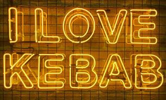 neon splendente cartello nel giallo caldo colore su un' mattone parete con il iscrizione o slogan io amore kebab. mattone parete, sfondo. luminosa elettrico neon luce. bar-ristorante doner kebab. foto