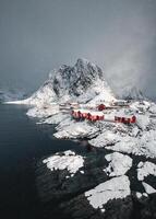 nevicando nel Hamnoy pesca villaggio con nevoso montagna su costa a lofoten isole foto