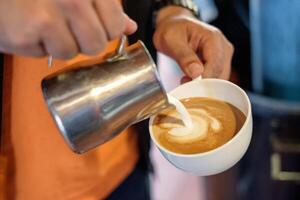 barista scrosciante latte su caffè tazza fabbricazione cuore foto