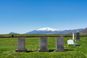 pietra sepolcrale su erba nel cristiano Chiesa cimitero nel estate a Islanda foto