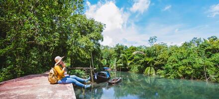 natura di viaggio donna asiatica. viaggio relax.una foto in barca. seduto a guardare la bellissima natura a tha pom-klong-song-nam. krabi, in thailandia.