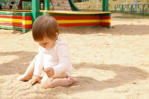 bambino giocando con sabbia su il terreno di gioco foto