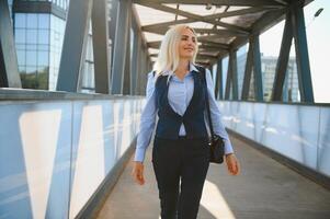 bellissimo donna andando per opera, attività commerciale donna a piedi vicino ufficio costruzione. ritratto di riuscito attività commerciale donna. foto