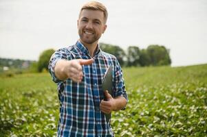 giovane agricoltore nei campi di soia foto