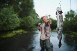 pescatore a mosca Tenere trota su di il acqua foto