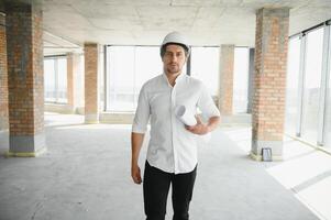 attività commerciale architetto uomo indossare elmetto protettivo in piedi di un' edificio progetto foto