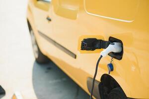 ricarica moderno elettrico auto a partire dal stazione, avvicinamento foto