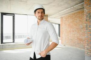 vicino su ingegneri Lavorando su un' edificio luogo Tenere un' progetti.ingegneria e architettura concetto foto