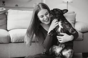 giovane donna con sua cane a casa. bello animale domestico foto