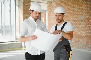 costruzione concetto di ingegnere e architetto Lavorando a costruzione luogo con blu Stampa. foto