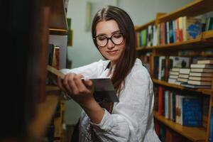 formazione scolastica, alto scuola, Università, apprendimento e persone concetto. sorridente alunno ragazza lettura libro foto