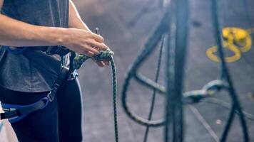 donna legatura il arrampicata corda con Due mani foto