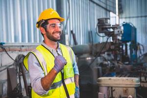 meccanico ingegneria in piedi nel acciaio fabbrica officina. industria robot programmazione Software per automatizzato produzione tecnologia foto