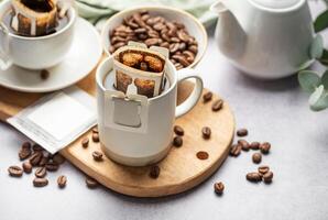 gocciolare caffè Borsa con terra caffè nel tazza foto