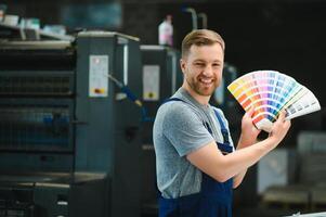 uomo Lavorando nel stampa Casa con carta e vernici foto