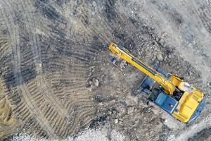 aereo Visualizza di il fermato giallo scavatrice a un' costruzione luogo foto