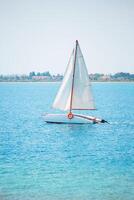 andare in barca il motore barca su il Aperto mare nel luce del sole su il acqua. dietro a siamo alberi e case su il costa. tempo libero, andare in barca, regata, avventura, rilassamento foto