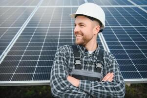esperto è ispezionando qualità di un' solare batterie. lavoratore nel uniforme e casco con attrezzatura. ecologia energia conservazione concetto. foto