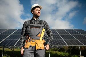 esperto è ispezionando qualità di un' solare batterie. lavoratore nel uniforme e casco con attrezzatura. ecologia energia conservazione concetto. foto