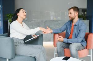 depressione Consulenza. disperato uomo telling di infelice vita mentre professionale psicologo assunzione Appunti durante appuntamento nel ufficio. selettivo messa a fuoco foto