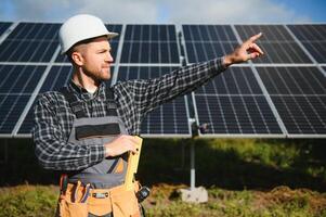 maschio lavoratore nel uniforme all'aperto con solare batterie a soleggiato giorno. foto