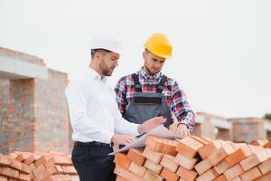 ingegnere architetto con difficile cappello e sicurezza veste Lavorando insieme nel squadra su maggiore costruzione luogo foto