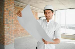 ritratto di uomo architetto a edificio luogo. fiducioso costruzione manager indossare elmetto protettivo. riuscito maturo civile ingegnere a costruzione luogo con copia spazio. foto