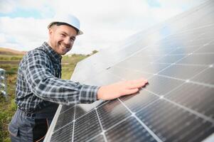 esperto è ispezionando qualità di un' solare batterie. lavoratore nel uniforme e casco con attrezzatura. ecologia energia conservazione concetto. foto