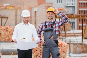 ingegnere architetto con difficile cappello e sicurezza veste Lavorando insieme nel squadra su maggiore costruzione luogo foto