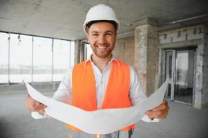 ritratto di uomo architetto a edificio luogo. fiducioso costruzione manager indossare elmetto protettivo. riuscito maturo civile ingegnere a costruzione luogo con copia spazio. foto